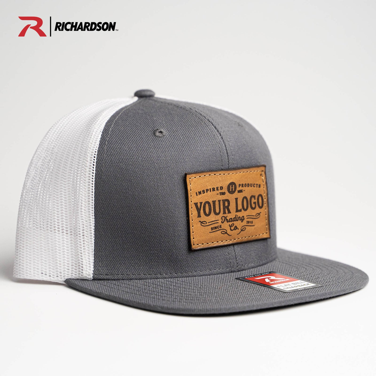 Gray and white Richardson 511 trucker hat with customized logo on a leather patch from Holtz Leather Co in Huntsville, Alabama