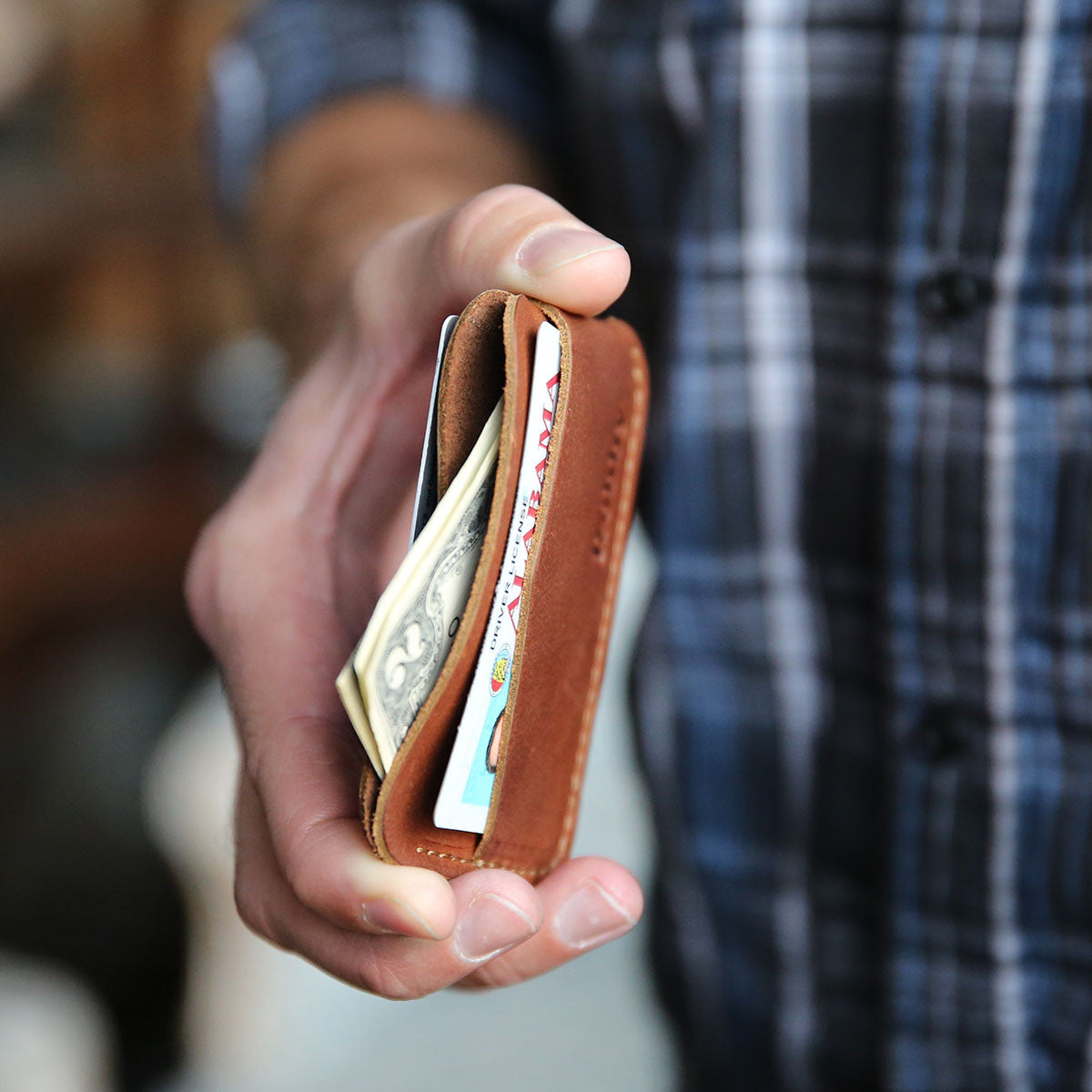 Fine leather triple sleeve front pocket wallet in a person's hand
