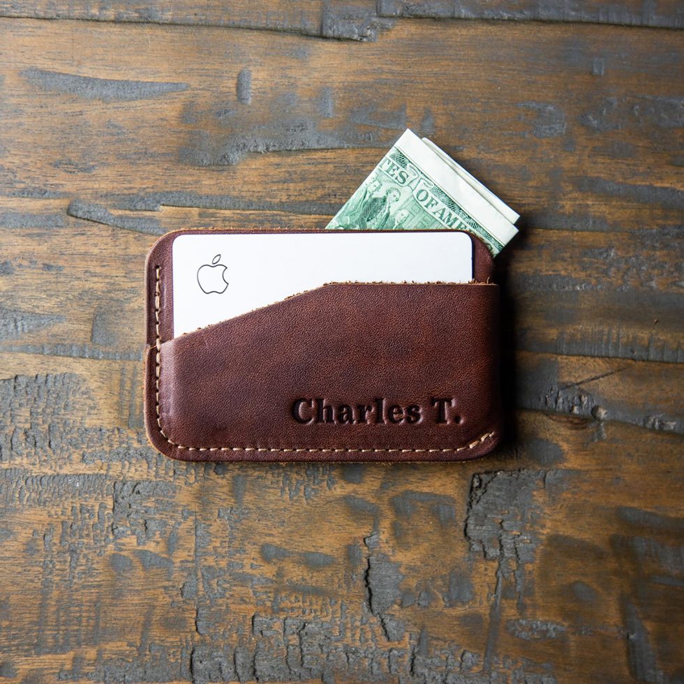 Fine leather triple sleeve front pocket wallet in a person's hand